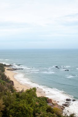 Vahşi kumlu plaj tropikal el değmemiş doğa ile çevrili kayalar ile görünümünü