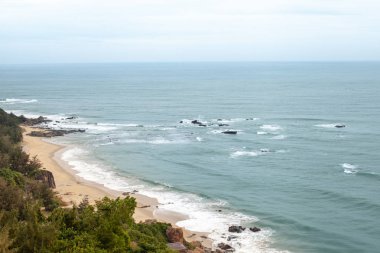 Vahşi kumlu plaj tropikal el değmemiş doğa ile çevrili kayalar ile görünümünü