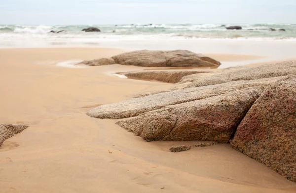 Kumlu sahilde büyük granit taşlar. Arka plan görüntüsü. Alan metni kopyalayın