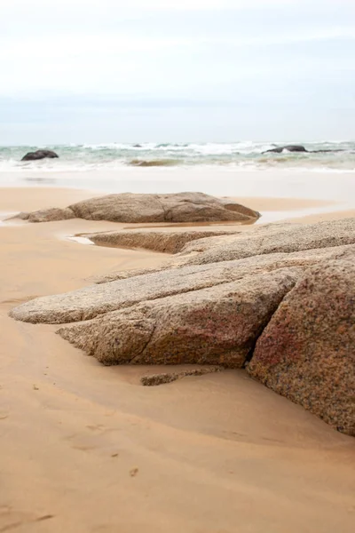 Kumlu sahilde büyük granit taşlar. Arka plan görüntüsü. Alan metni kopyalayın