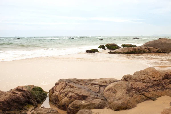 Kumlu sahilde büyük granit taşlar. Arka plan görüntüsü. Alan metni kopyalayın