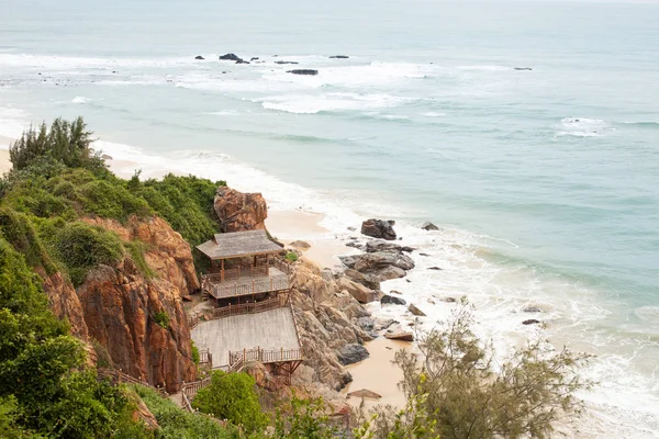 Kayalar ve tropikal yeşil arasında bir görüntüleme platformu ile deniz kıyısında ahşap merdiven