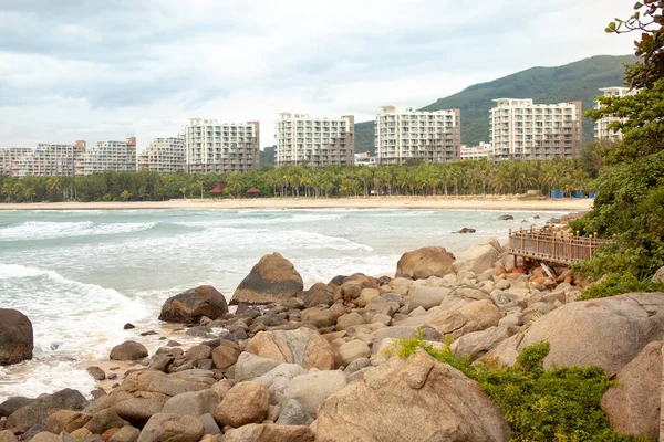 Tropikal ağaçlar ve bitki örtüsü deniz manzarası ile turistik kentin kıyısında büyük kayalar üzerinde