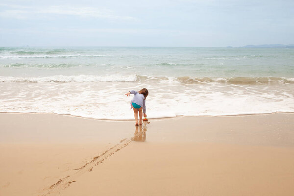 The concept of a beach holiday with a five-year-old child. Games on the sandy beach.