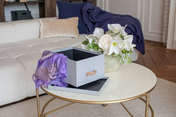 Box with folded things in the interior of the apartment