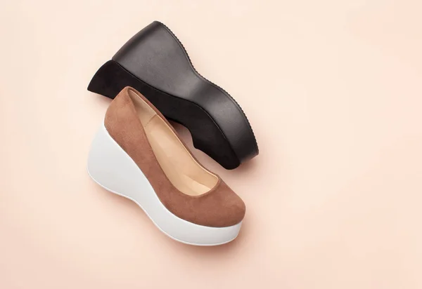 A brown suede women's platform heel Shoe next to a black one on a pink background. — Stock Photo, Image