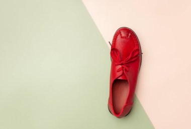 Pembe ve yeşil arka plan üzerinde kırmızı kadın deri sonbahar mokasen.