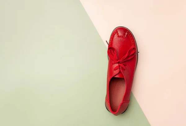 Red women's leather autumn moccasin on pink and green background. — Stock Photo, Image