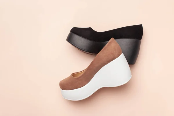 A brown suede women's platform heel Shoe next to a black one on a pink background. — Stock Photo, Image