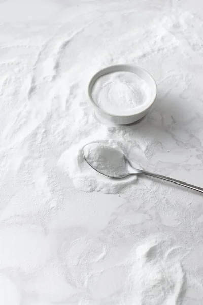 Baking soda in a bowl and in a spoon on the marble countertop — Stock Photo, Image