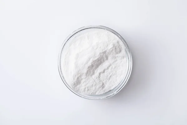 Bicarbonato de sodio en un frasco y un tazón en una mesa blanca — Foto de Stock