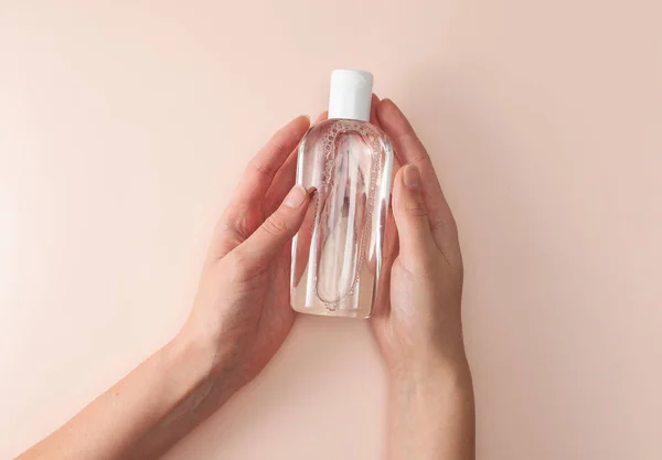 Пляшка з міцелярною очищувальною водою в жіночих руках — стокове фото