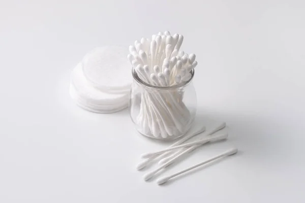 Cotton buds in a jar, cotton pads on a gray background. — Stock Photo, Image