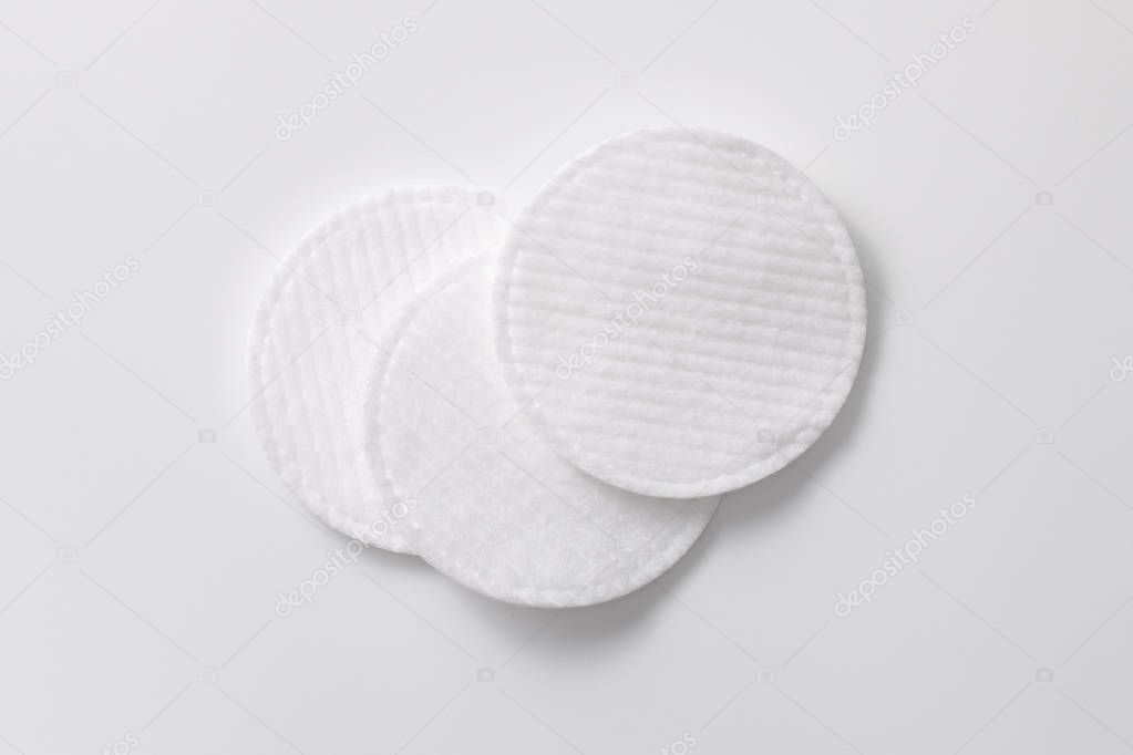 Cotton pads for removing cosmetics on a gray plain background