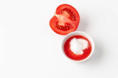 Beyaz arka planda organik domates suyu ve kabartma tozu manzarası. Kozmetik alanında domatesler ve beyaz arka planda folklor tarifleri. Boşluk metnini kopyala.