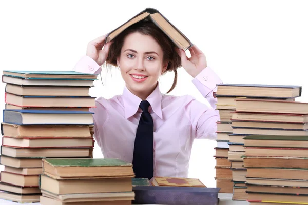 Junges lustiges Mädchen sitzt am Schreibtisch mit Büchern Buch. — Stockfoto