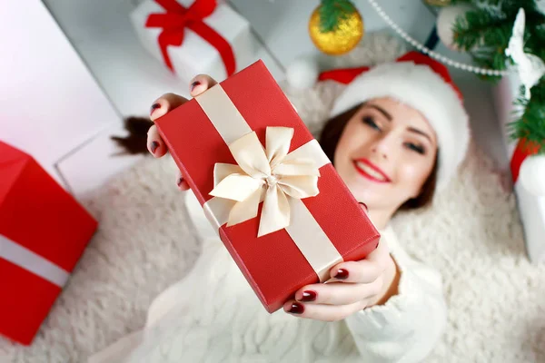 Happy young woman lying on the floor with gift box. — Stock Photo, Image