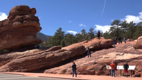 Garden Gods Hanging Rock Показывает Люди Поднимаются Известное Место Парке — стоковое видео