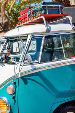 Hortumu mavi gökyüzü ve palmiye ağaçlarıyla dolu eski bir araç.