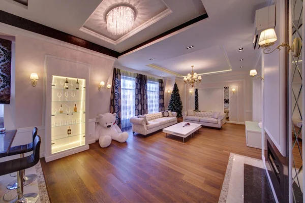 The big living room with white furniture and a dark wooden parquet