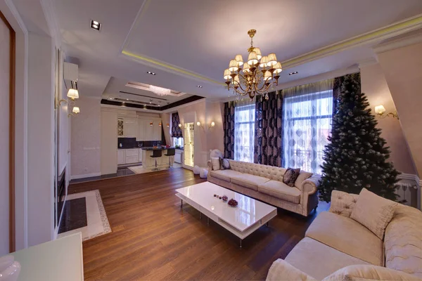 The living room with light furniture and a dark wooden floor