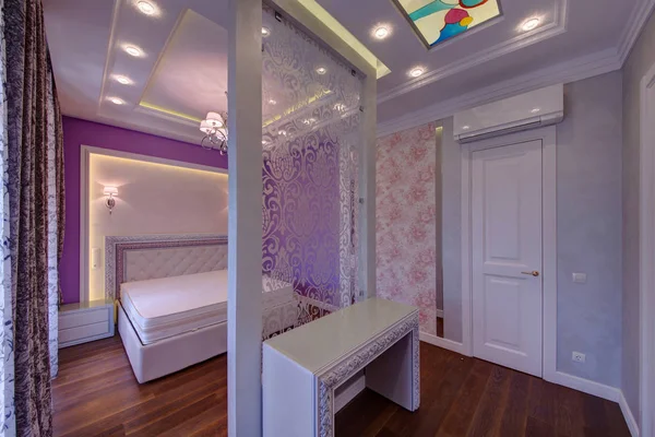 The room with a partition and a bed, a dressing table and a stained-glass window on a ceiling