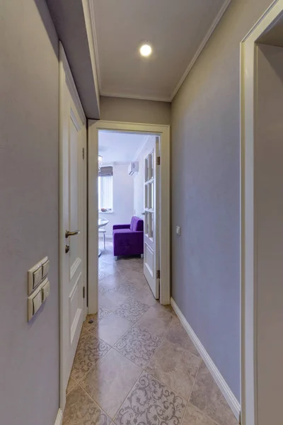 Sebuah Koridor Yang Menghadap Dapur Dengan Sofa Ungu — Stok Foto