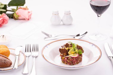 Kapari ile sığır eti ve sebze ve Yeşiller ile rendelenmiş peynir Tartar bir tabak vermek