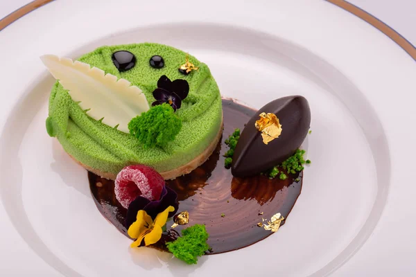 The sweet shortcake dough dessert with a pillow from mousse, moves with ice cream and flowers