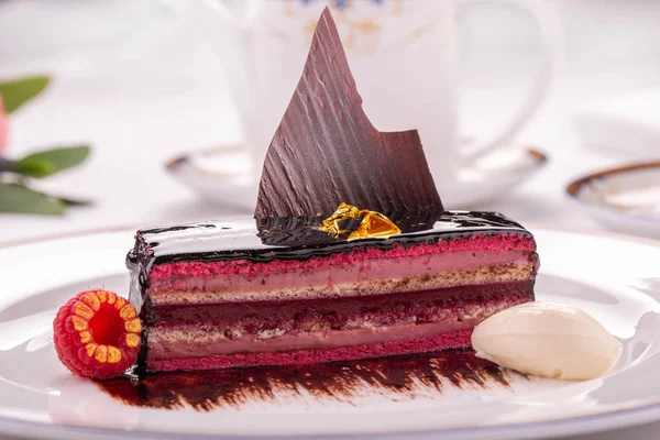 Sütlü çikolata tabağı ile dekore edilmiş çocuk oyuncağı ahududu ve bir top dondurma ile servis edilir