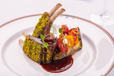 Bir sebze iliği ile kurutulmuş domates ile kuzu ve Erik sosu raf bir garnitür servis edilir