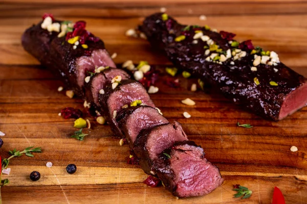 Pedaços Carne Cortados Uma Tábua Madeira Com Avelãs Pimenta — Fotografia de Stock