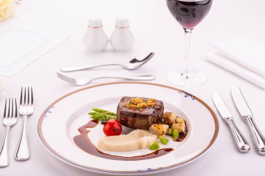 Bir sığır eti hissesi püresi gelen bir kereviz bir kuşkonmaz ve Porto sosu ile