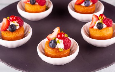 Siyah opak tabakta küçük beyaz düz yemekler çeşitli tatlılar