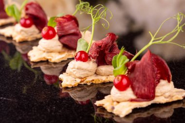 Yeşillikleri ile küçük somun üzerinde kurutulmuş geyik eti ile mousse