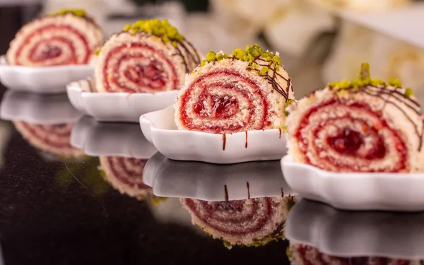 The cherry roll watered with chocolate is also strewed with a pistachio crumb