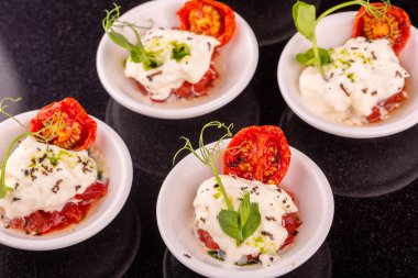 Tartlets peynir mozzarella yeşil ve yeşil yağ ile kurutulmuş domates ile gelen