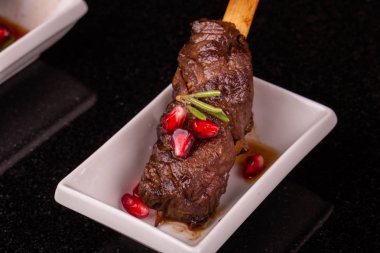 Bir ızgara koyun eti garnet suyu ve Yeşiller ile servis edilir