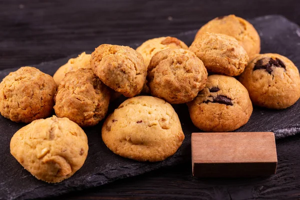 Cookies with chocolate, nuts on black granite