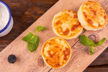 Cheesecakes, ekşi krema ve broşürler nane ile servis edilir