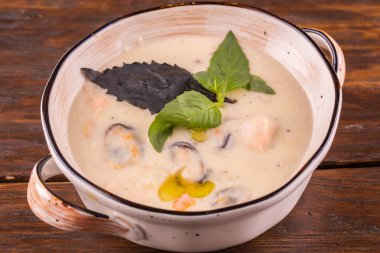 Krem çorbası, karides ve midye yeşillikleri ile servis edilir