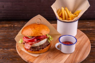 Burger kızarmış pirzola, peynir ve domuz pastırması, ızgara sebze, patates kızartması ve ketçap ile servis edilir