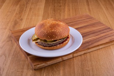Ahşap oyun tahtası beyaz tabakta Burger