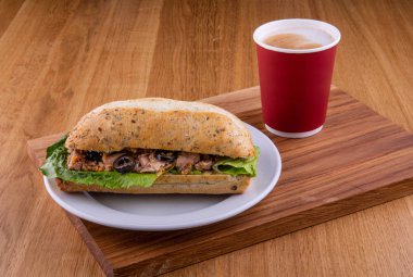 Sandviç ölüm nedeni ile bir fincan kahve ile ahşap bir gemide bir tabakta servis edilir