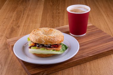 Kırmızı balık, bir fincan kahve ile ahşap bir gemide bir tabakta kuru domates sandviç