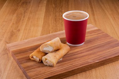 Bir fincan kahve ile ahşap bir tahta üzerinde süzme peynir ile Pancakes