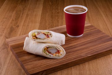 Bir fincan kahve ile ahşap bir gemide bir somon ile sarılmış Tokmaklar