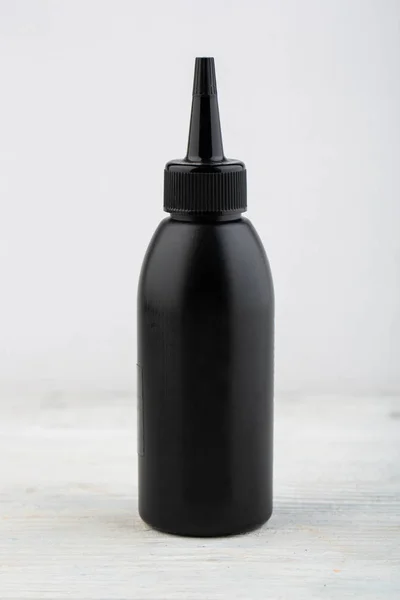 Una Pequeña Botella Negra Con Champú Para Cabello — Foto de Stock