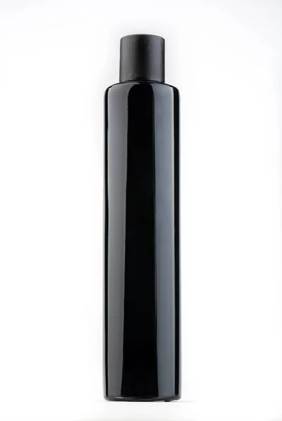 Una Pequeña Botella Negra Con Una Cubierta Opaca Debajo Del — Foto de Stock