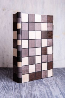 Siyah-beyaz bir açısal çini, bir örneğe bağlı olarak gri bir ahşap arka plan